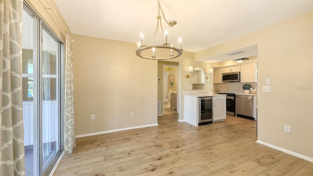 445 Matisse Cir S Unit 445, Nokomis, FL 34275 - kitchen with stainless steel appliances, beverage cooler, a chandelier, light countertops, and light wood-type flooring