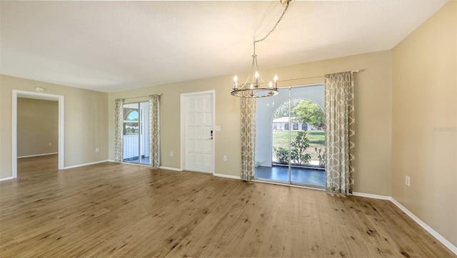 445 Matisse Cir S Unit 445, Nokomis, FL 34275 - unfurnished dining area featuring a chandelier, wood finished floors, and baseboards