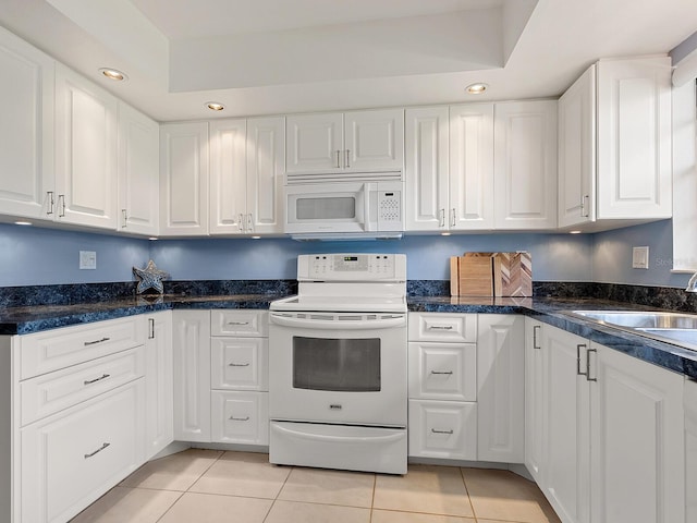 kitchen featuring white appliances, light tile patterned floors, white cabinets, a sink, and recessed lighting