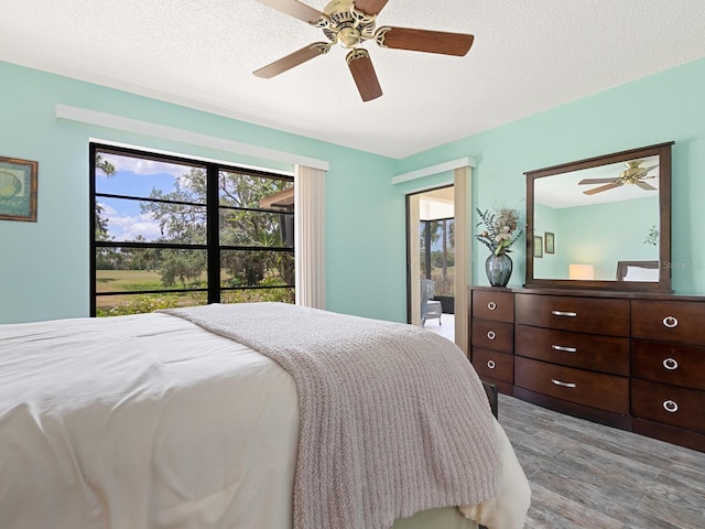 bedroom featuring wood finished floors, a ceiling fan, and a textured ceiling