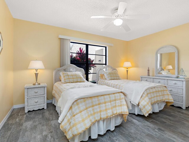 bedroom featuring wood finished floors, a textured ceiling, baseboards, and a ceiling fan