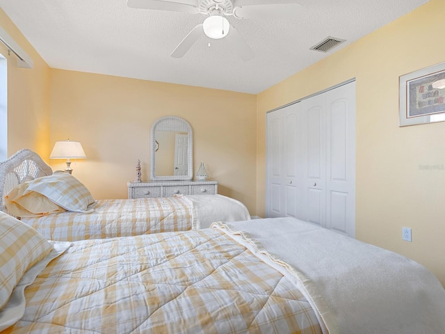 bedroom featuring a closet, ceiling fan, and a textured ceiling