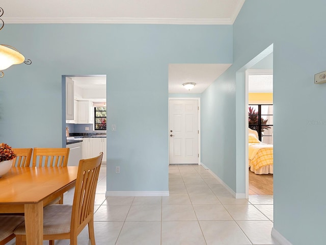 dining area with crown molding, light tile patterned floors, and baseboards