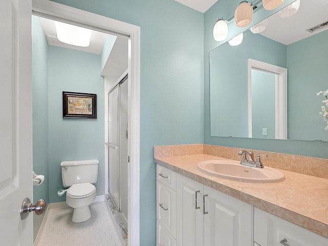 bathroom with toilet, vanity, tile patterned flooring, a shower stall, and baseboards
