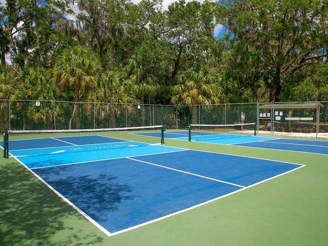 view of tennis court featuring fence and community basketball court