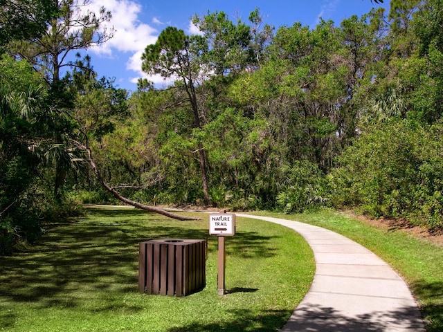 surrounding community with a yard and a wooded view