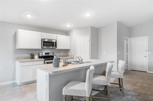 1446 Appaloosa St, Port Charlotte, FL 33980 - kitchen with stainless steel appliances, a sink, a kitchen bar, white cabinetry, and baseboards
