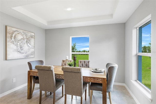 1446 Appaloosa St, Port Charlotte, FL 33980 - dining space featuring a tray ceiling, light tile patterned floors, and baseboards