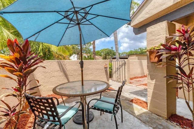view of patio featuring a gate, outdoor dining area, and fence