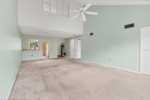 unfurnished living room with high vaulted ceiling, carpet flooring, a ceiling fan, and baseboards