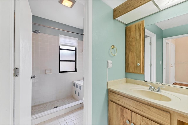 full bathroom featuring tiled shower, vanity, and tile patterned floors