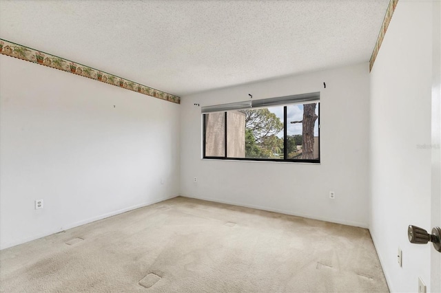 unfurnished room with carpet flooring and a textured ceiling