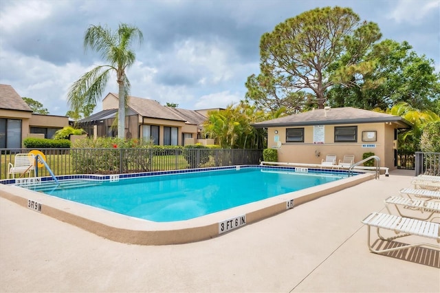 community pool featuring fence and a patio