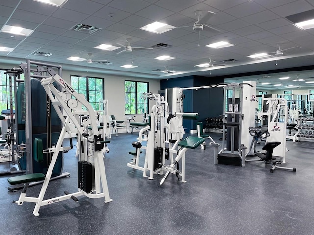 gym featuring a drop ceiling and a ceiling fan