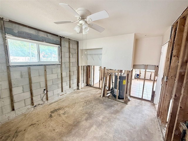 1726 8th St, Sarasota, FL 34236 - spare room featuring water heater, unfinished concrete floors, ceiling fan, and concrete block wall