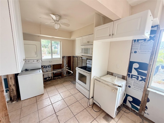 1726 8th St, Sarasota, FL 34236 - kitchen with white appliances, stacked washer / dryer, a ceiling fan, white cabinetry, and light tile patterned flooring