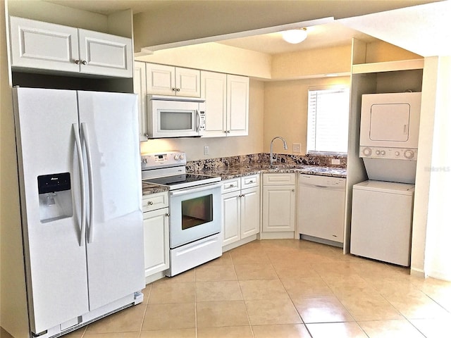 1726 8th St, Sarasota, FL 34236 - kitchen featuring white appliances, stacked washer / dryer, a sink, and white cabinets
