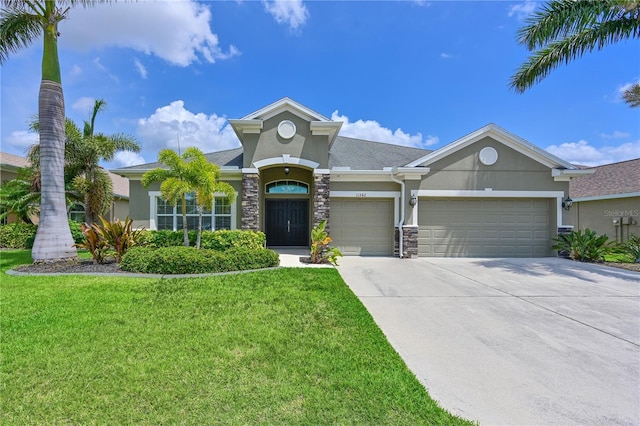 view of front of house featuring stucco siding, an attached garage, a front yard, driveway, and stone siding
