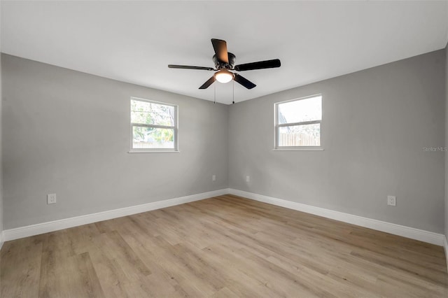 empty room featuring baseboards, light wood finished floors, and a ceiling fan