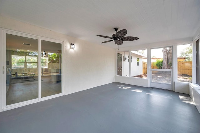 unfurnished sunroom featuring a ceiling fan