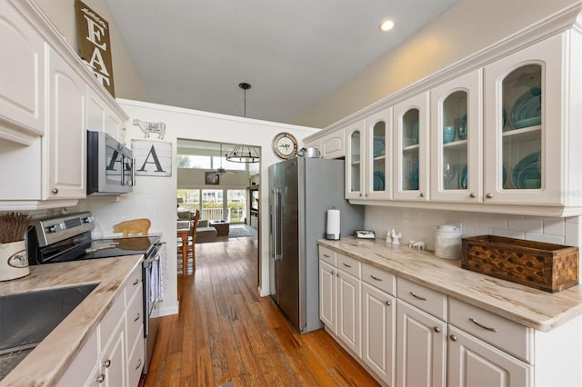 kitchen featuring appliances with stainless steel finishes, white cabinetry, glass insert cabinets, decorative backsplash, and recessed lighting