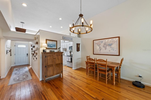 dining area featuring a chandelier, light wood-style floors, baseboards, and recessed lighting
