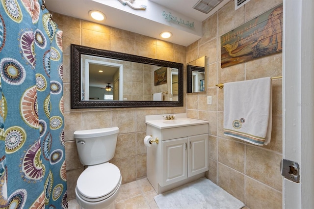 full bath featuring tile walls, toilet, vanity, curtained shower, and tile patterned floors