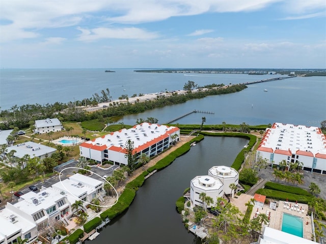 bird's eye view of a nearby body of water, a pool, and apartment complex / building