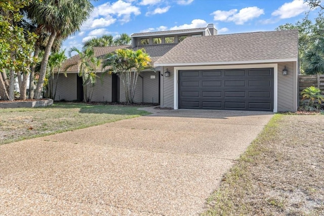 mid-century inspired home featuring concrete driveway, a garage, and a front lawn