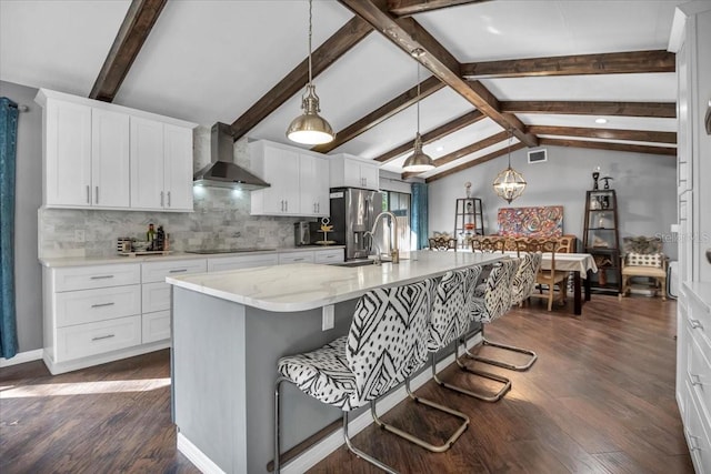 kitchen featuring wall chimney exhaust hood, a sink, black electric cooktop, dark wood finished floors, and stainless steel refrigerator with ice dispenser