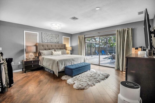 bedroom featuring access to exterior, wood finished floors, and baseboards