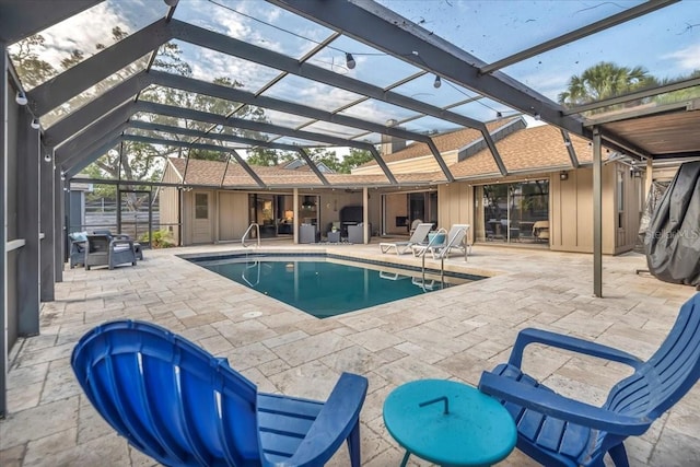 outdoor pool featuring glass enclosure and a patio