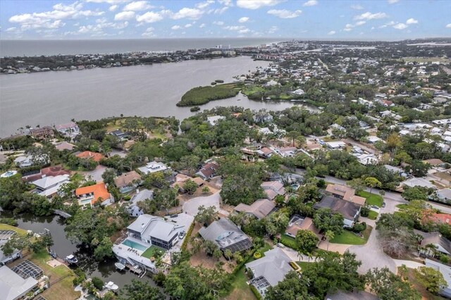 aerial view of property and surrounding area featuring a nearby body of water and nearby suburban area