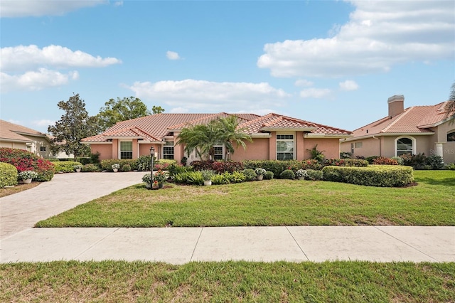 431 Fieldstone Dr, Venice, FL 34292 - mediterranean / spanish-style house with stucco siding, a tiled roof, and a front lawn