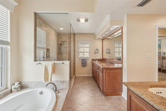 431 Fieldstone Dr, Venice, FL 34292 - full bathroom with tiled shower, two vanities, a garden tub, baseboards, and tile patterned flooring