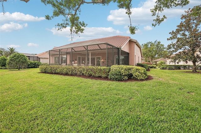 431 Fieldstone Dr, Venice, FL 34292 - back of house featuring a lawn, glass enclosure, stucco siding, and a tile roof