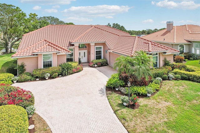 431 Fieldstone Dr, Venice, FL 34292 - mediterranean / spanish-style home featuring a tiled roof, an attached garage, decorative driveway, stucco siding, and a front lawn