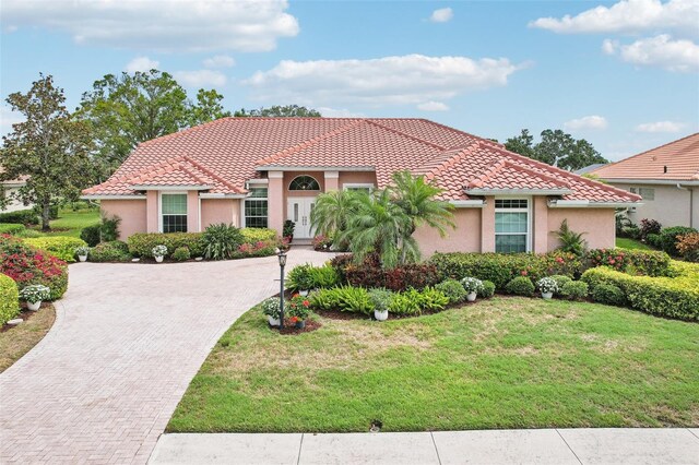 431 Fieldstone Dr, Venice, FL 34292 - mediterranean / spanish-style house featuring a tile roof, stucco siding, a front yard, and decorative driveway