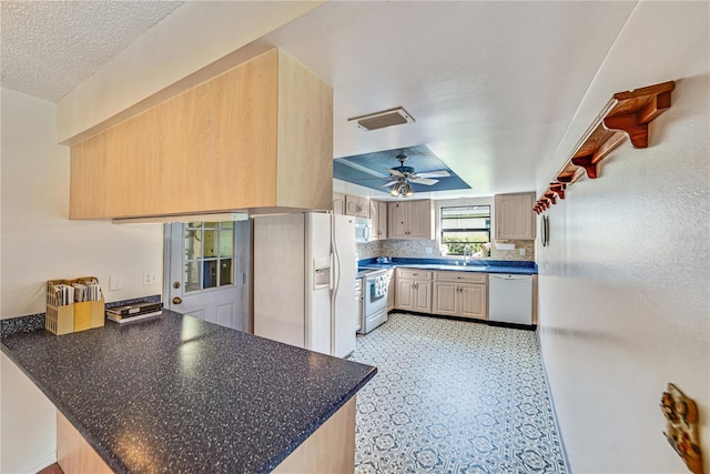 2607 Lancaster Dr Unit 35, Sun City Center, FL 33573 - kitchen with white appliances, ceiling fan, a peninsula, a sink, and dark countertops
