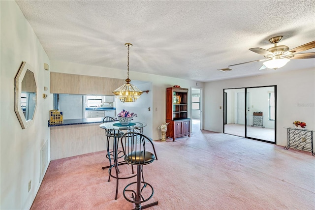 2607 Lancaster Dr Unit 35, Sun City Center, FL 33573 - dining space featuring a textured ceiling, a chandelier, light colored carpet, and ceiling fan