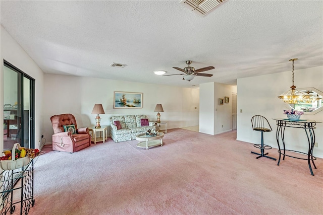 2607 Lancaster Dr Unit 35, Sun City Center, FL 33573 - living area featuring light carpet, a textured ceiling, ceiling fan, baseboards, and a chandelier