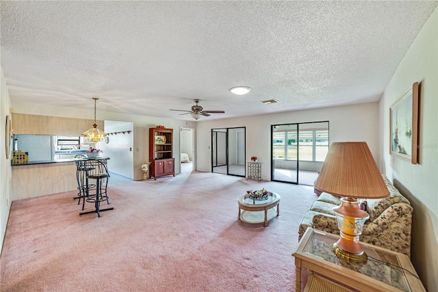 2607 Lancaster Dr Unit 35, Sun City Center, FL 33573 - living area featuring a textured ceiling, light colored carpet, and a ceiling fan
