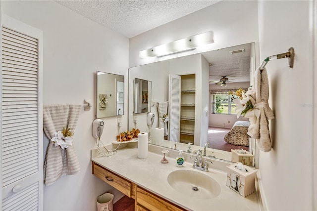 2607 Lancaster Dr Unit 35, Sun City Center, FL 33573 - bathroom featuring a textured ceiling, ceiling fan, vanity, and a closet