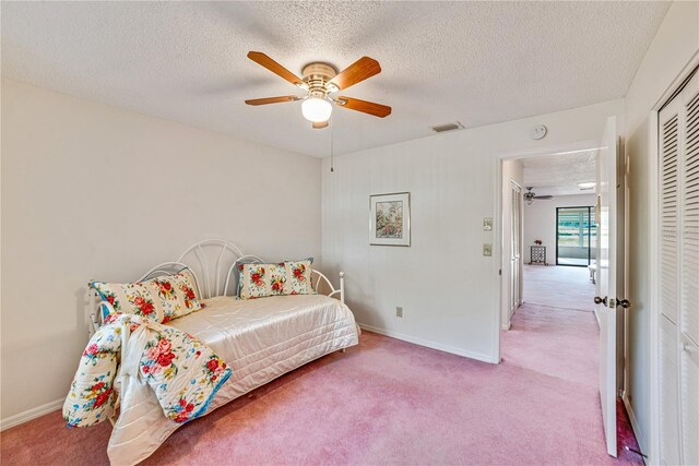 2607 Lancaster Dr Unit 35, Sun City Center, FL 33573 - bedroom with light carpet, a closet, a textured ceiling, baseboards, and a ceiling fan
