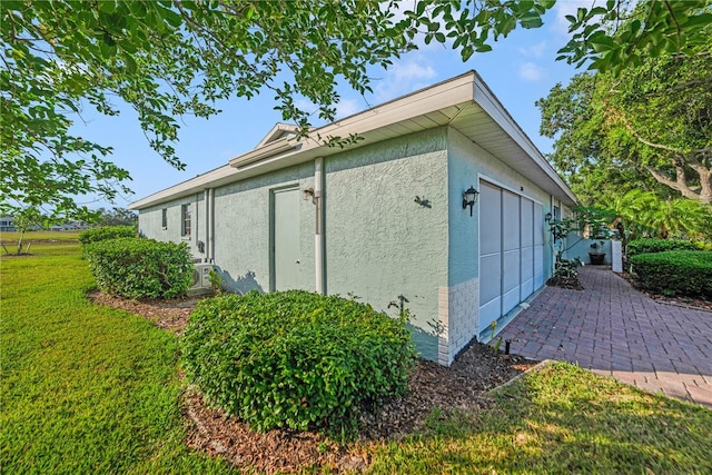 2607 Lancaster Dr Unit 35, Sun City Center, FL 33573 - view of property exterior featuring a garage, stucco siding, and a yard