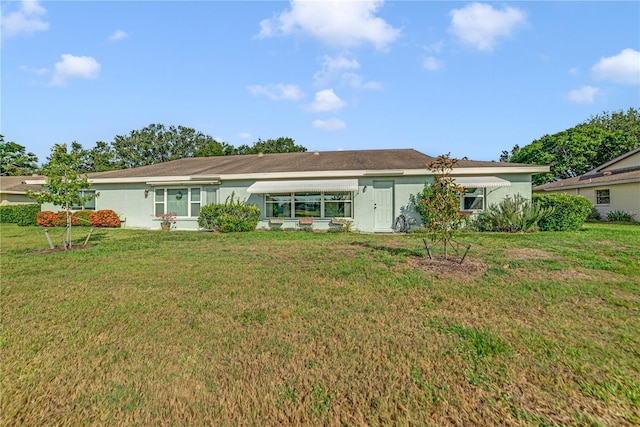 2607 Lancaster Dr Unit 35, Sun City Center, FL 33573 - rear view of property featuring a lawn and stucco siding