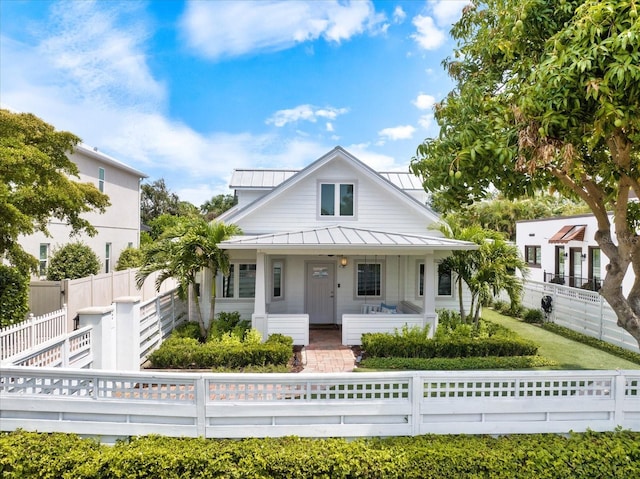 1841 Datura St, Sarasota, FL 34239 - view of front of house with a porch, a standing seam roof, a fenced front yard, and metal roof