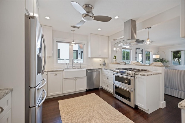 1841 Datura St, Sarasota, FL 34239 - kitchen featuring stainless steel appliances, a sink, island exhaust hood, a peninsula, and decorative backsplash