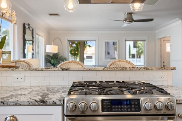 1841 Datura St, Sarasota, FL 34239 - kitchen featuring stainless steel gas range oven, decorative backsplash, ornamental molding, a ceiling fan, and light stone counters