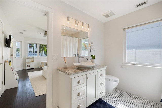 1841 Datura St, Sarasota, FL 34239 - ensuite bathroom with vanity, ceiling fan, toilet, and wood finished floors